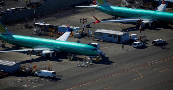 FILE PHOTO: A worker walks past unpainted Boeing 737 MAX aircraft parked at Renton Municipal