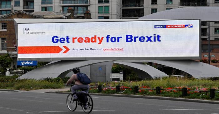 FILE PHOTO: A cyclist rides past an electronic billboard displaying a British government Brexit