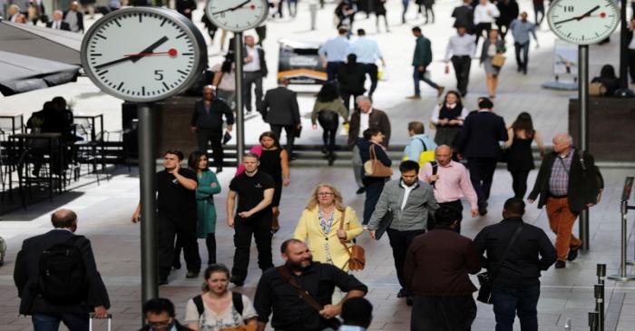 FILE PHOTO: People walk through the financial district of Canary Wharf, London, Britain 28