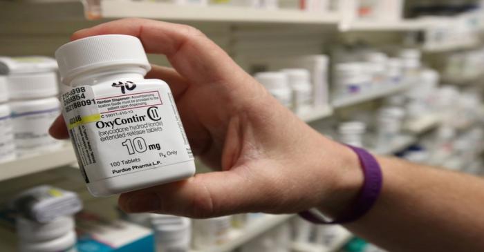 FILE PHOTO: A pharmacist holds a bottle OxyContin made by Purdue Pharma at a pharmacy in Provo,