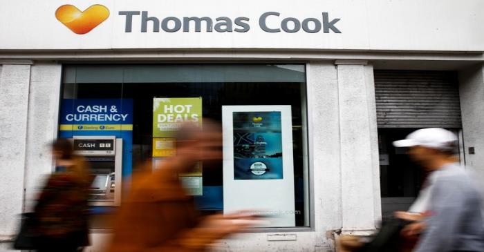 FILE PHOTO:  People walk past a closed Thomas Cook store in London