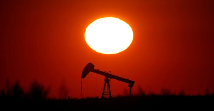 The sun sets behind a pump-jack outside Saint-Fiacre