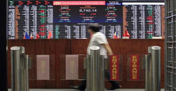 A stockbroker looks at the electronic board inside the Philippine Stock Exchange (PSE) in