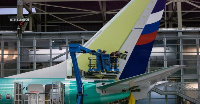 Boeing employees work on the tail of a Boeing 737 NG at the Boeing plant in Renton, Washington