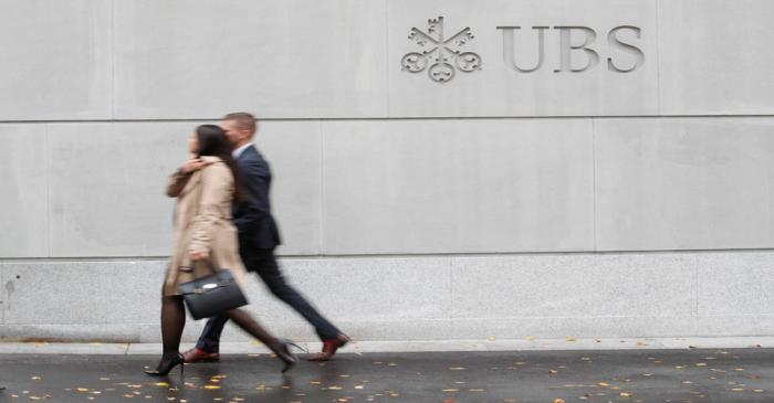 People walk past a logo of Swiss bank UBS in Zurich,