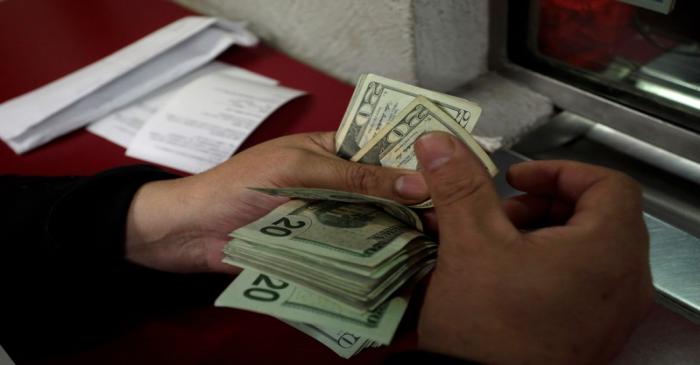 Employee counts U.S. dollar banknotes at a foreign exchange house in Monterrey