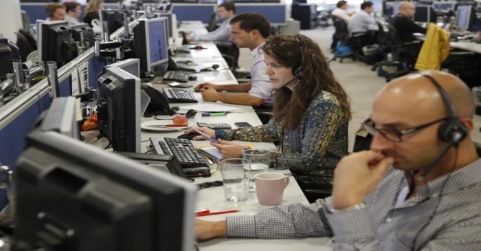 Traders sit at their desks at IG Index in London