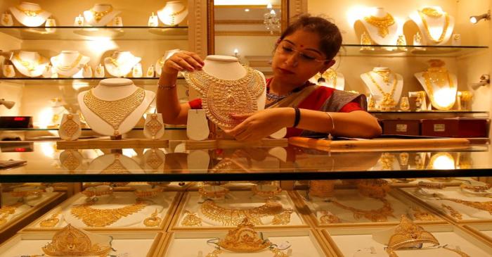 A saleswoman displays a gold necklace inside a jewellery showroom on the occasion of Akshaya