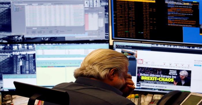 FILE PHOTO: Share trader reacts as he reads 