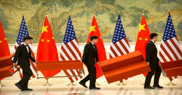 Aides set up platforms before a group photo with members of U.S. and Chinese trade negotiation