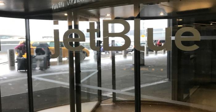 The JetBlue Airways logo is seen on a revolving door entering John F. Kennedy Airport in the
