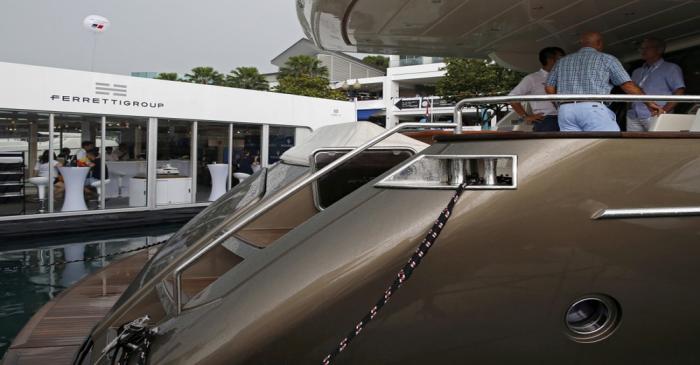 FILE PHOTO: Prospects inspect a Ferretti Riva yacht at the Singapore Yacht Show on Sentosa
