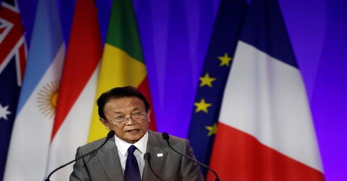 Japanese Finance Minister Taro Aso delivers a speech during a high-level forum on debt at the