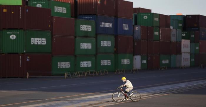 Man cycles by shipping containers in Tokyo