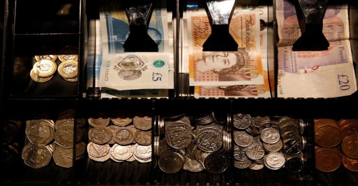 Pound Sterling notes and change are seen inside a cash resgister in a coffee shop in Manchester