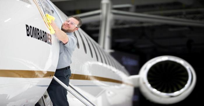 Bombardier employee polishes sign of Bombardier's Global 7500, the first business jet to have a