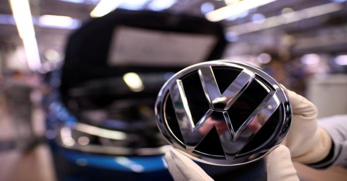 FILE PHOTO: An employee holds a Volkswagen logo in a production line at the Volkswagen plant in