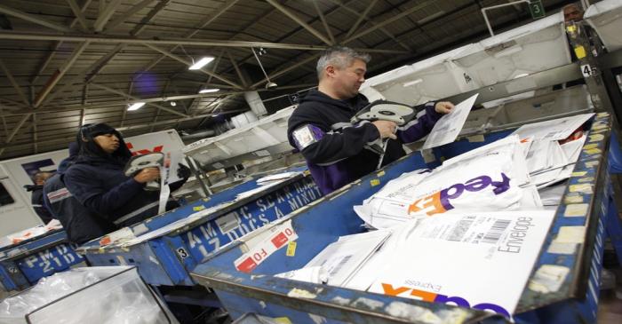 Handlers place letters and envelopes into cartons at the Marina Del Rey, California FedEx