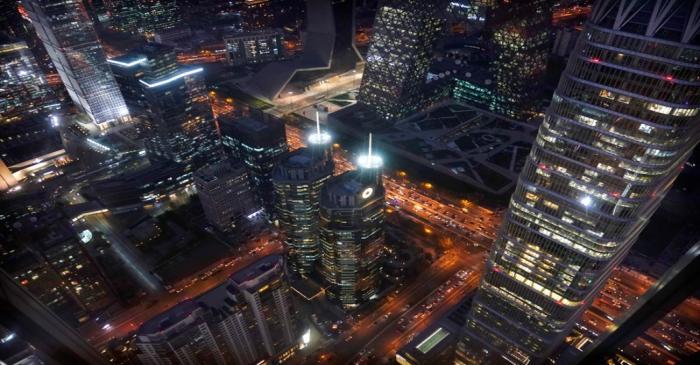 Vehicles drive among the buildings during the evening rush hour in Beijing's central business