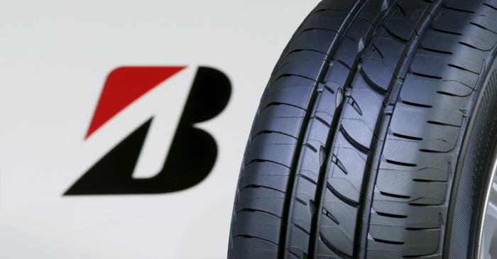 The logo of Bridgestone Corp is seen next to its new Playz tyre during the tyre's unveiling