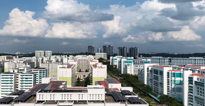 A view of public apartment blocks, with solar panels affixed to the roof of some blocks, in