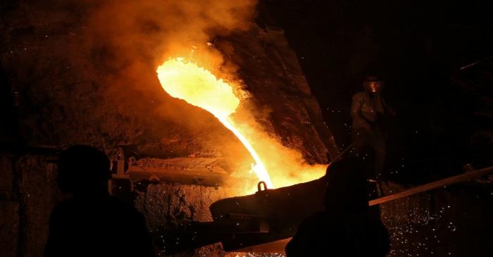 FILE PHOTO: A worker observes an electric furnace inside a steel factory on the outskirts of