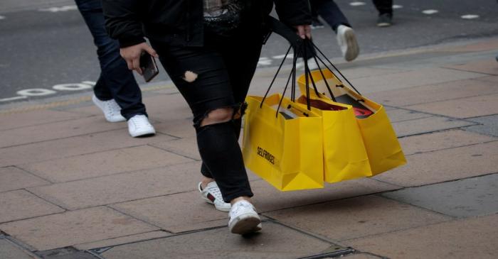 FILE PHOTO: Shoppers carry bags from a department store in Oxford Street, in London