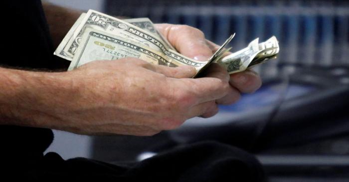 FILE PHOTO: A customer counts his cash at the register while purchasing an item at a Best Buy