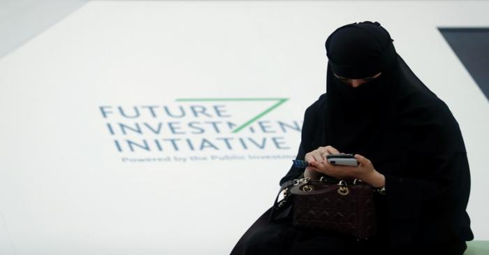 A Saudi woman uses her phone during the Future Investment Initiative conference in Riyadh