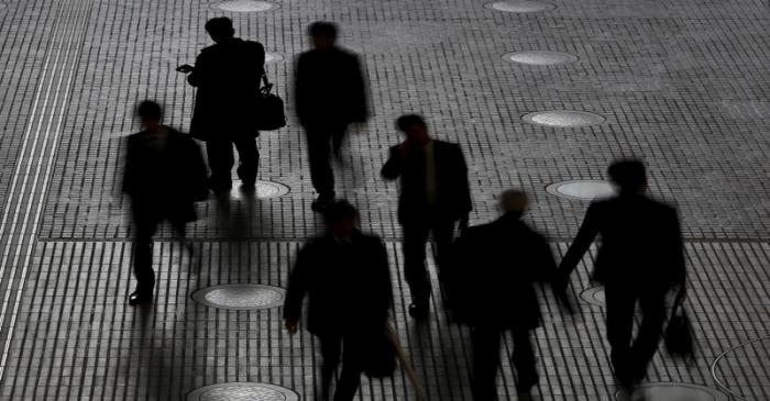 People walk at an office building at a business district in Tokyo