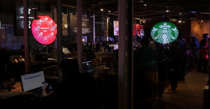 A Starbucks logo is reflected on a window at the shop in Rosebank