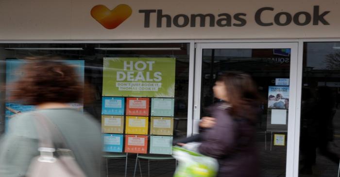 People walk past a closed Thomas Cook travel agents store near Manchester, Britain