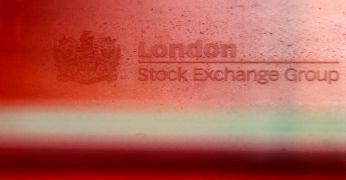 A red London bus passes the Stock Exchange in London