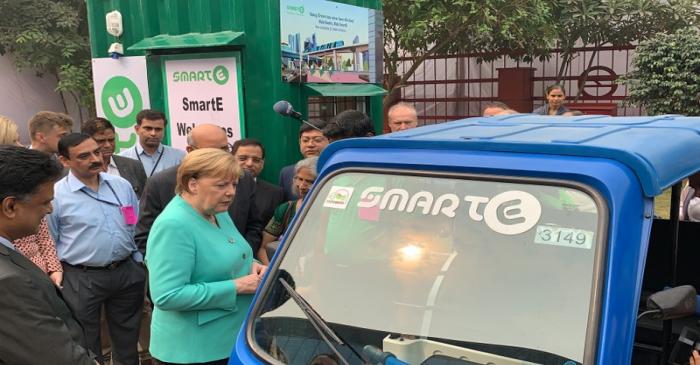 FILE PHOTO: German Chancellor Angela Merkel stands next to an electric vehicle during her visit