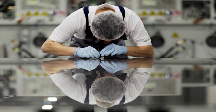 A worker of Signet Solar checks a photovoltaic module in a plant in Mochau near Dresden