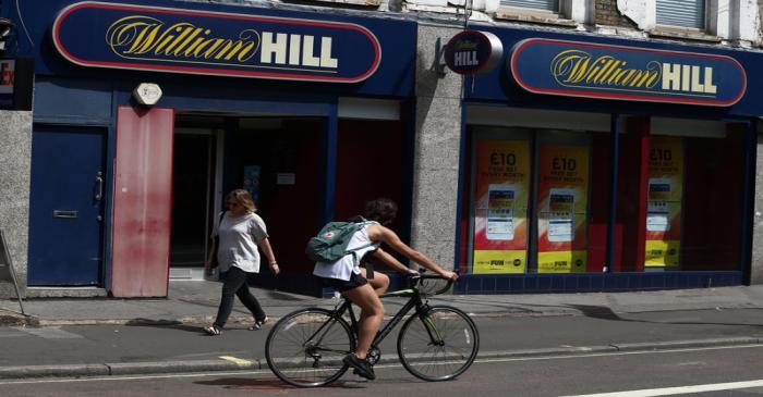 A cyclist passes a William Hill betting shop in London