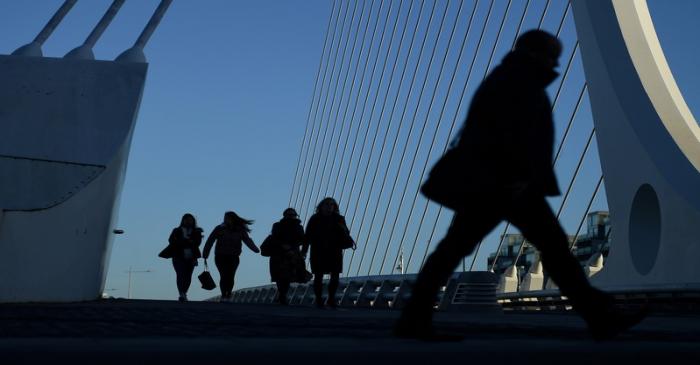 FILE PHOTO: Commuters make their way into work in the morning in the financial district of