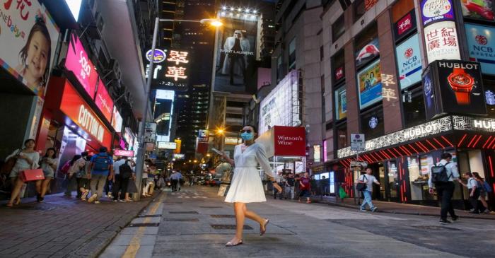 FILE PHOTO: A woman crosses a street in the Central business district in Hong Kong