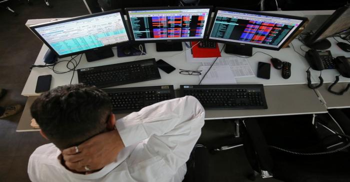 A broker reacts while trading at his computer terminal at a stock brokerage firm in Mumbai