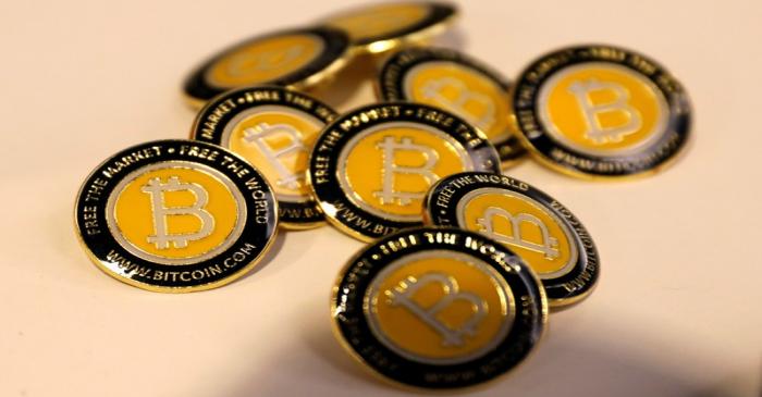 FILE PHOTO: Bitcoin.com buttons are seen displayed on the floor of the Consensus 2018