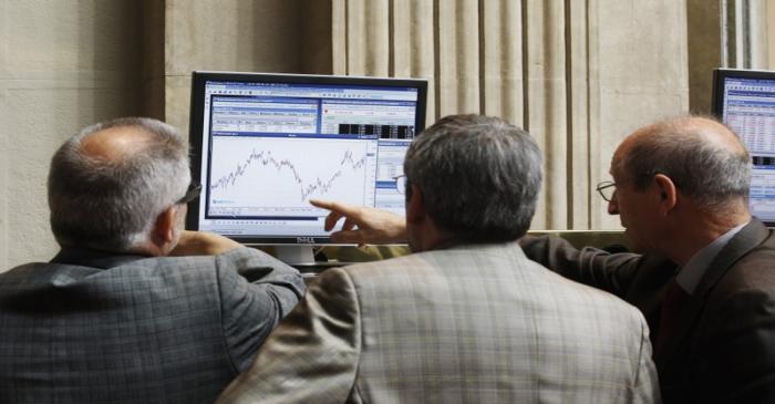 Traders look at a computer screen at the Madrid Bourse