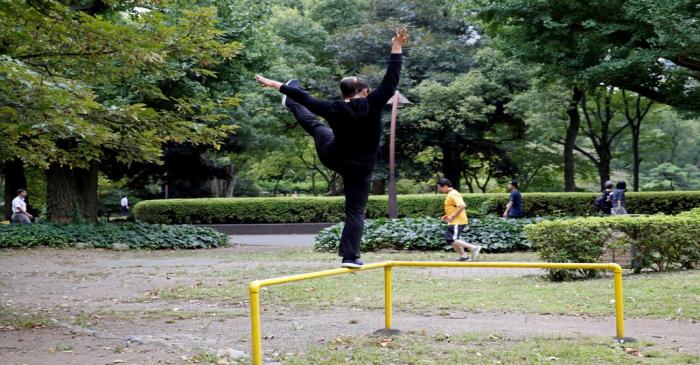 FILE PHOTO: Office worker exercises during a lunch break at a park in central Tokyo