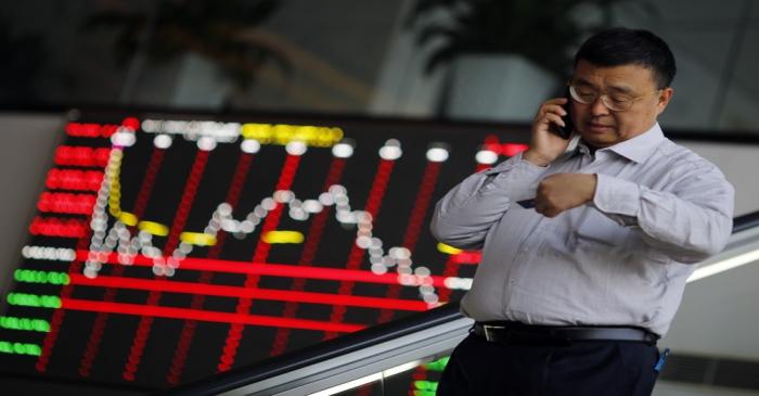 A man talks on the phone inside the Shanghai Stock Exchange building at the Pudong financial