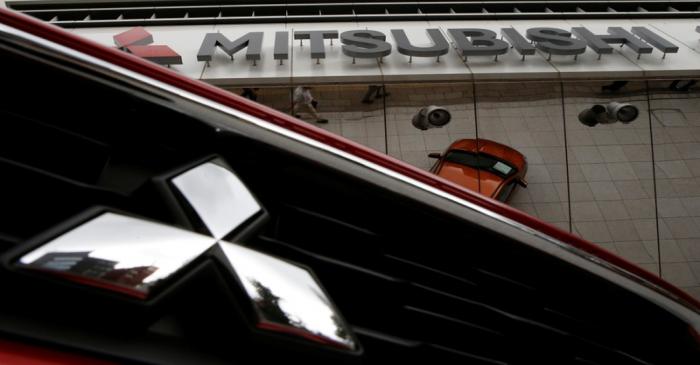 Mitsubishi Motors Corp's logo on a car and its company headquarters are seen in Tokyo