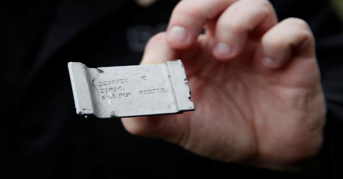 A member of the France's BEA aviation safety agency holds a piece of the engine of a Swiss Air