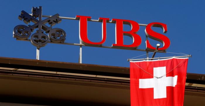 Switzerland's national flag flies under the logo of Swiss bank UBS in Zurich