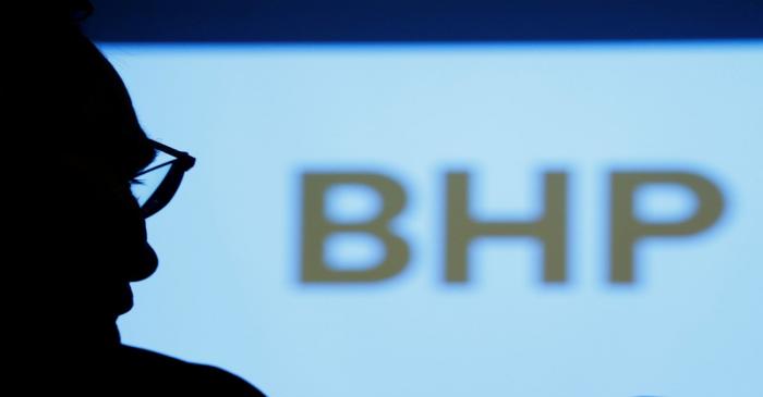FILE PHOTO: A BHP executive is silhouetted against a screen projecting the company's logo.