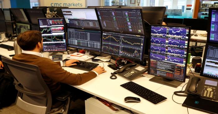 A financial trader works at their desk at CMC Markets in the City of London