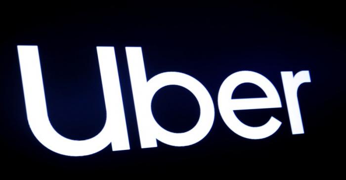 A screen displays the company logo for Uber Technologies Inc. on the day of it's IPO at the