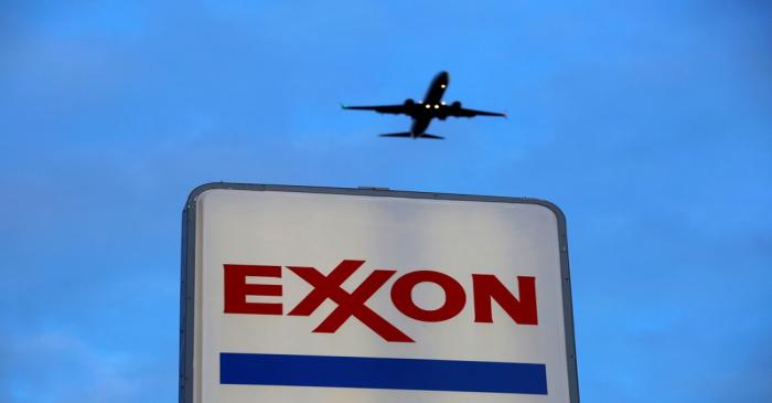 FILE PHOTO: An airplane comes in for a landing above an Exxon sign at a gas station in the